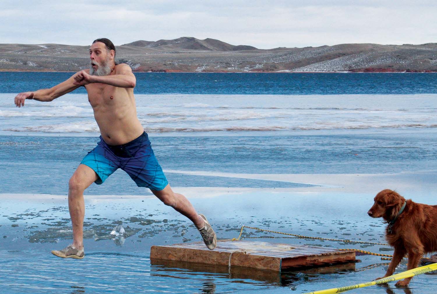 Gary Senier leaps into a frozen Lake Desmet on New Years Day